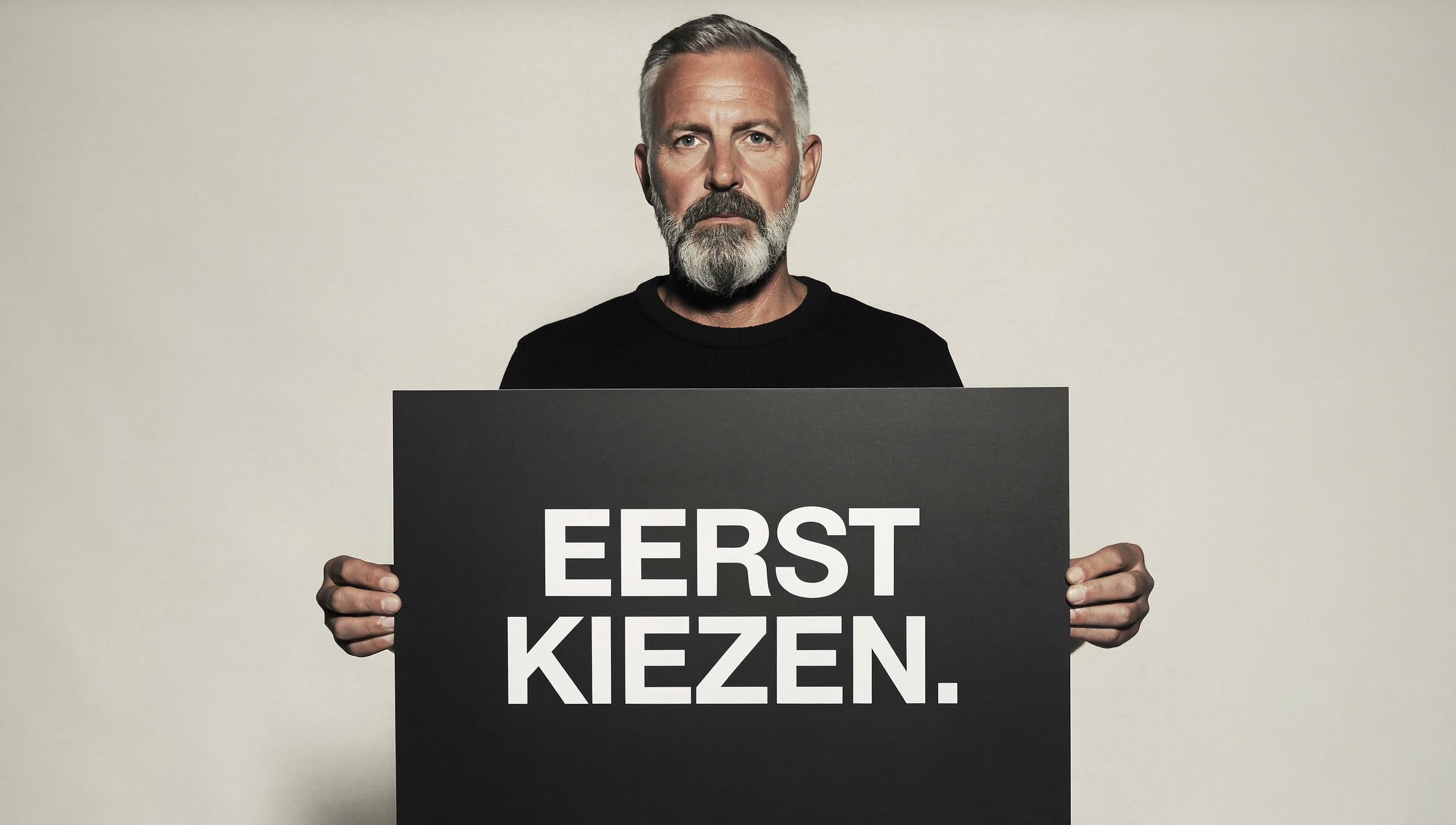 Deadpan man holding a black card reading EERST KIEZEN.